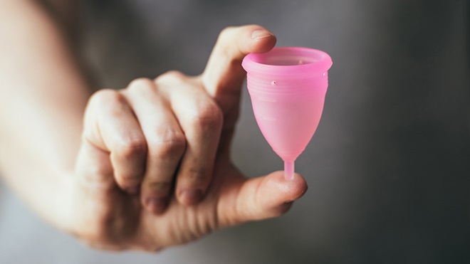 woman holding menstrual cup in hand
